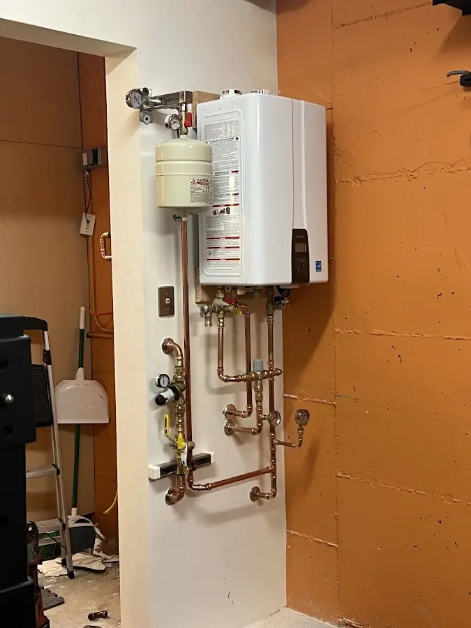 Plumbing technician inspecting water heater connections in Elwood